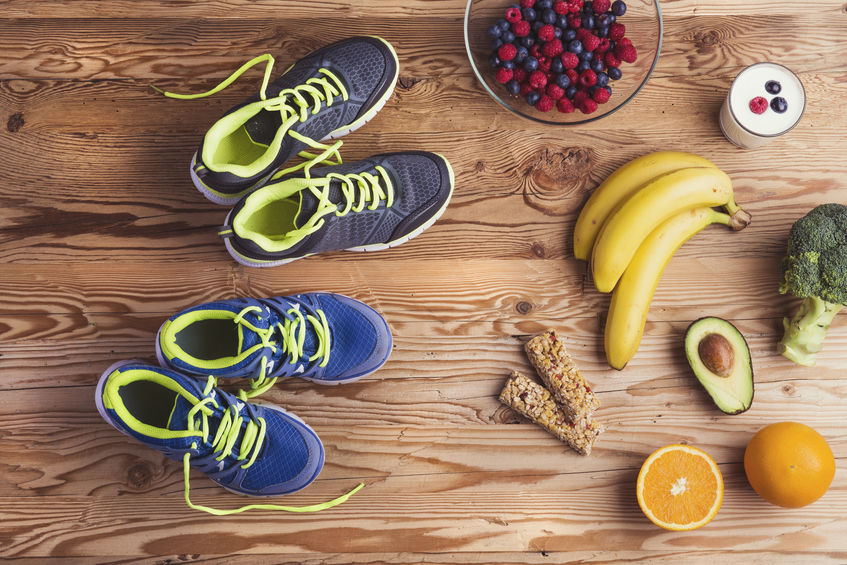 Top view of shoes and fruit on a wooden table.